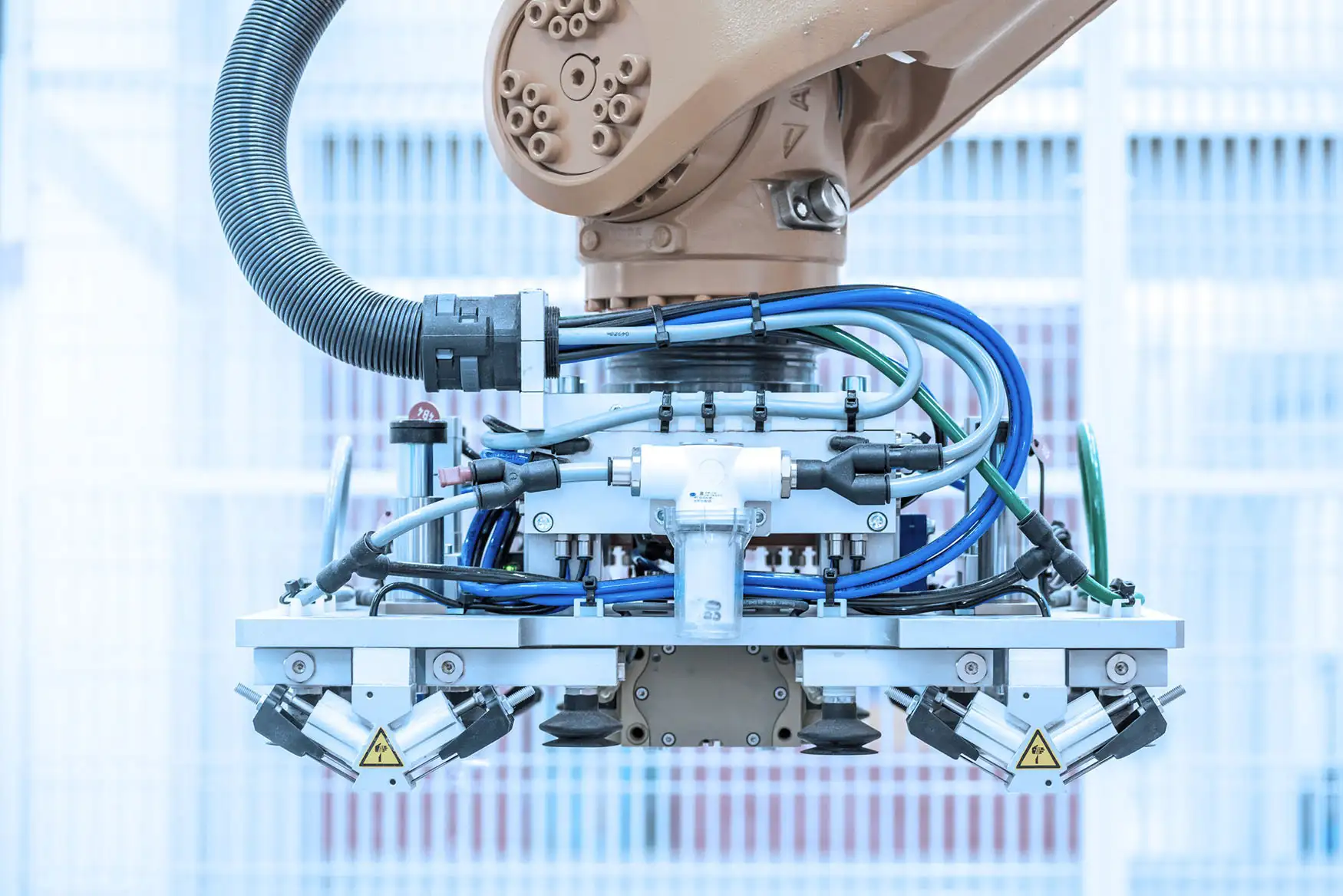 Ein Roboterarm hält ein Metallstück in einer industriellen Umgebung.